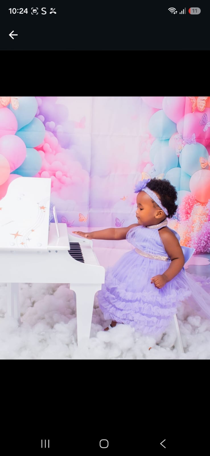 Toddler in a lilac tulle dress at a white piano