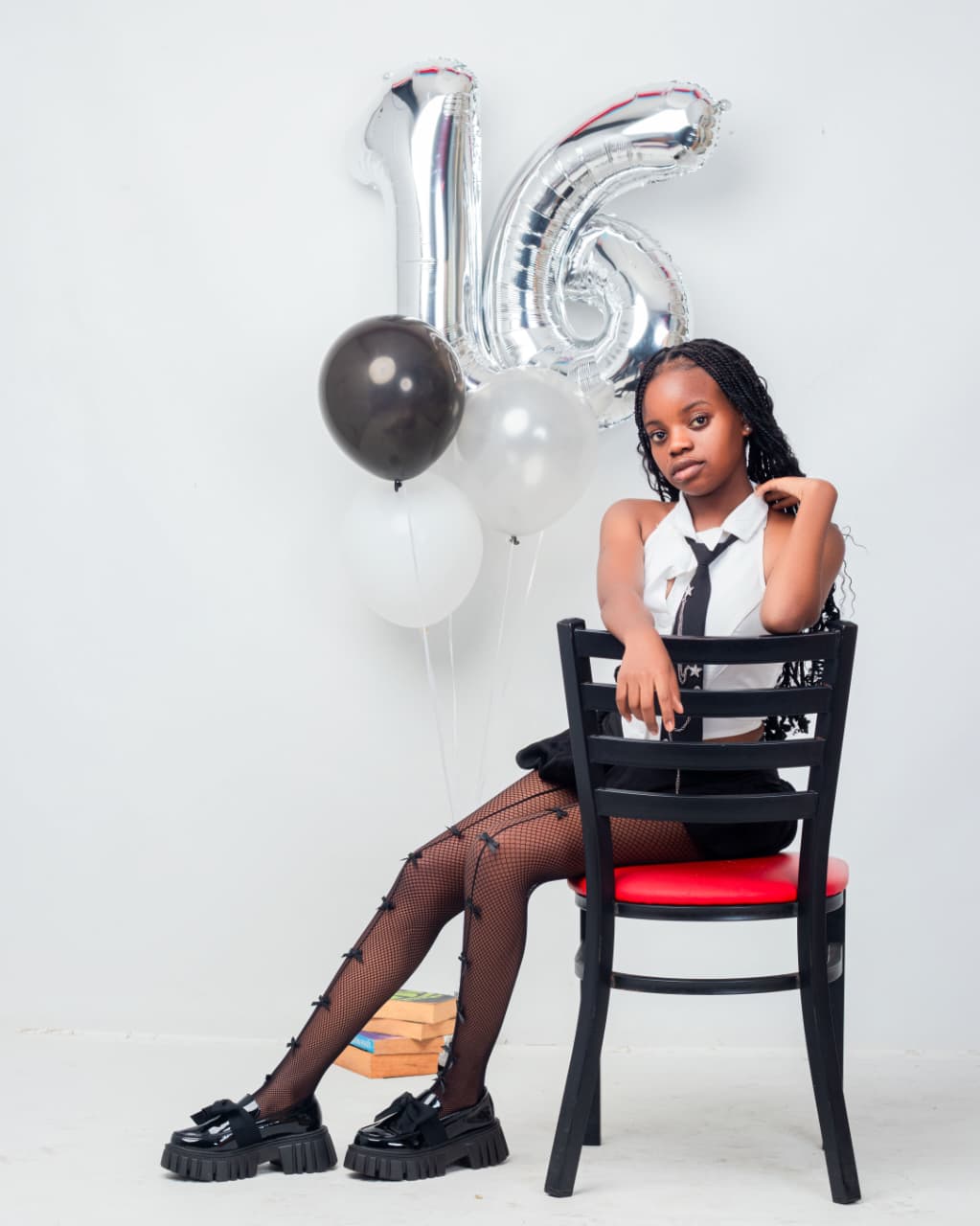 Sweet sixteen portrait with silver 16 balloons and black chair