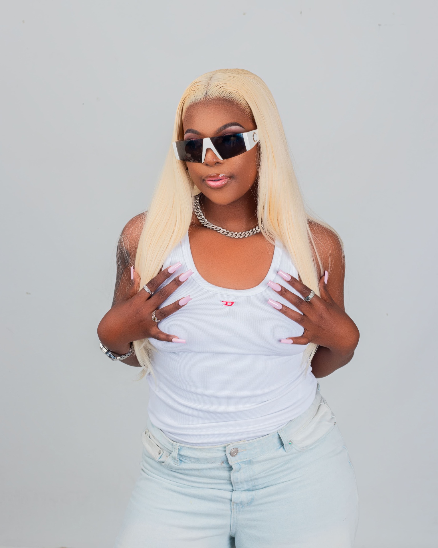 Close studio portrait of a blonde woman in white with sunglasses