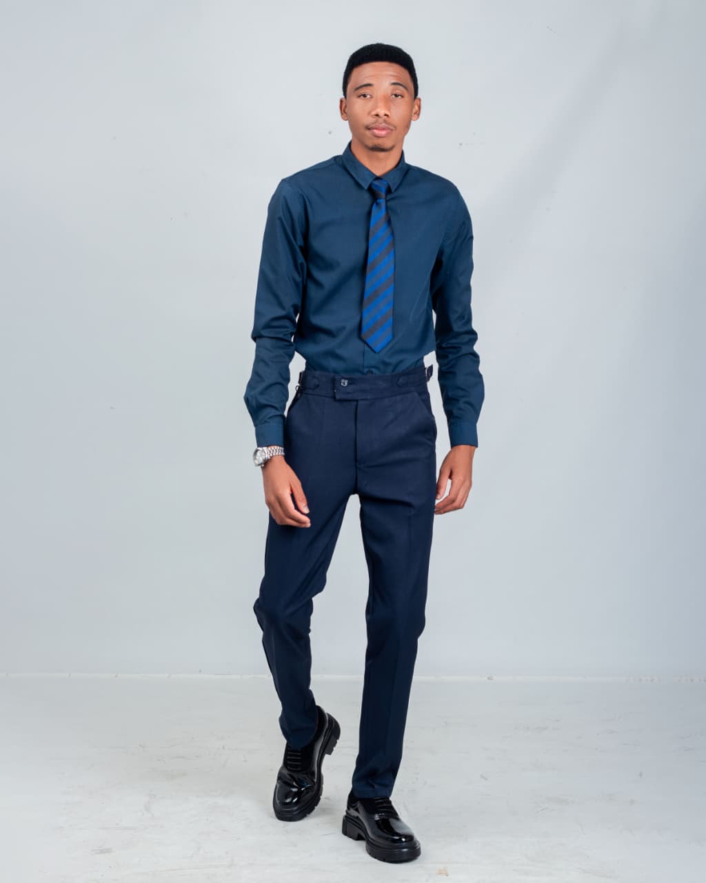Full-length studio portrait of a man walking in navy formalwear
