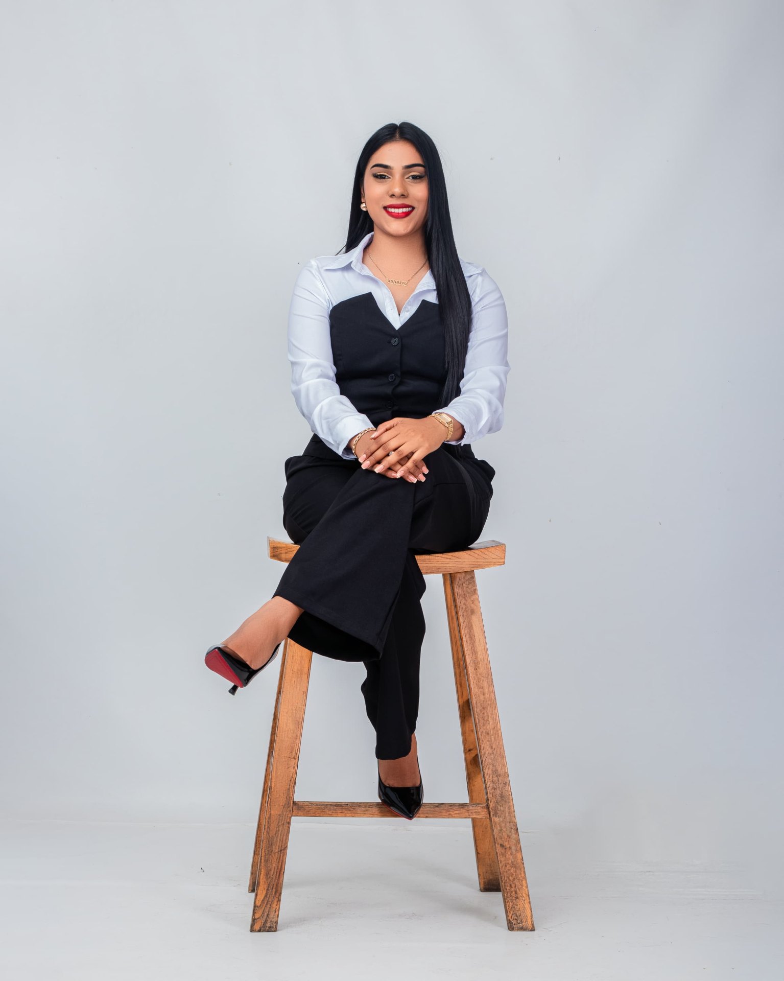 Professional woman seated in a black suit and white shirt