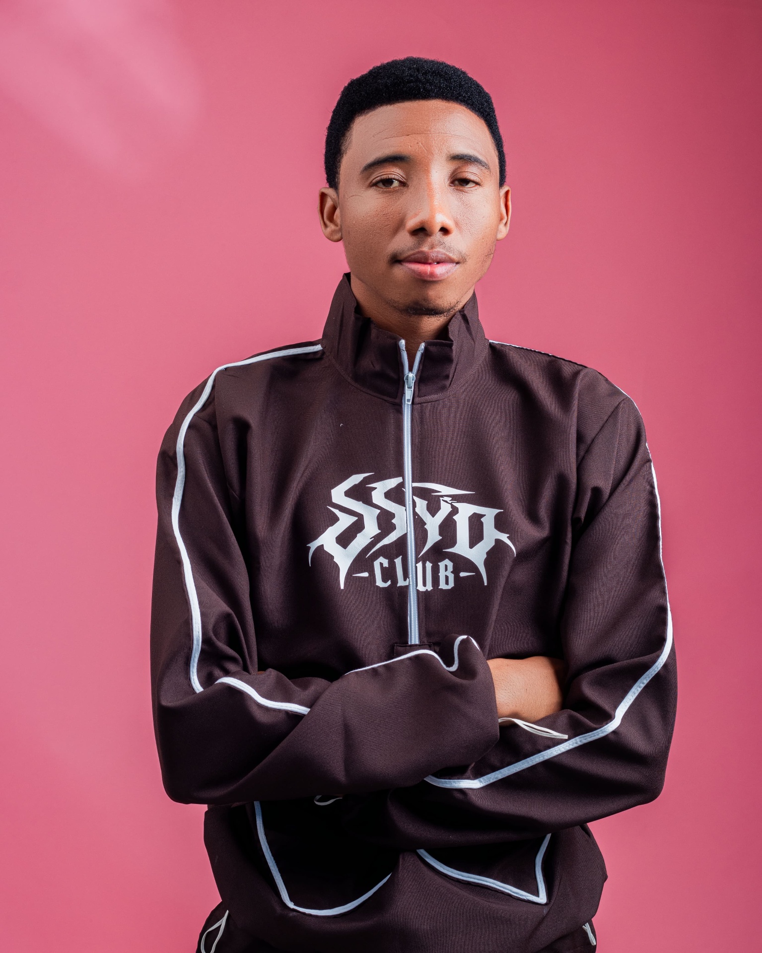 Half-length studio portrait of a man in black streetwear