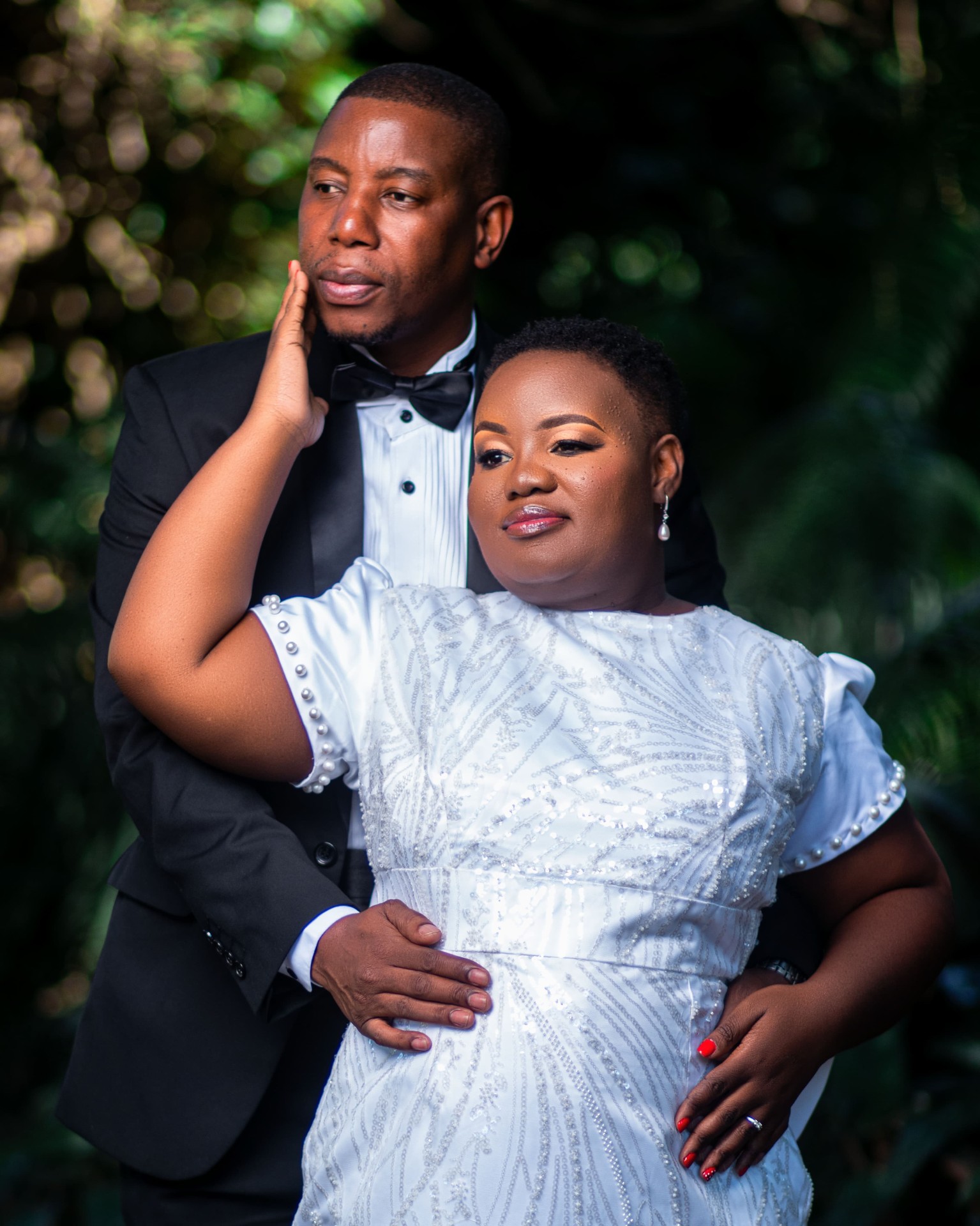 Couple embracing, she in a white beaded dress