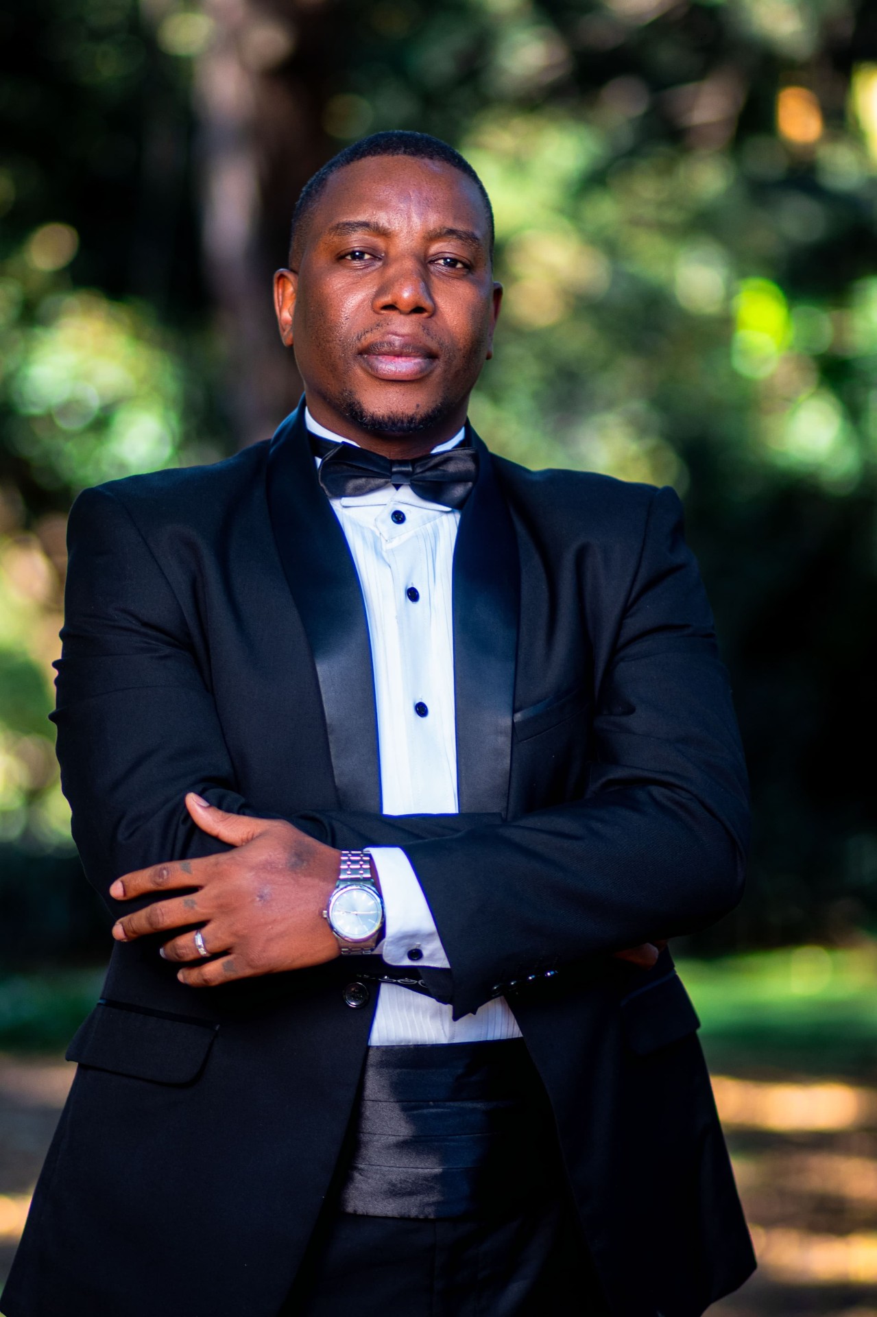 Outdoor portrait of a man in a black tuxedo and bow tie